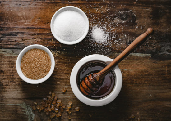 different kinds of sugar and maple syrup on a dark background